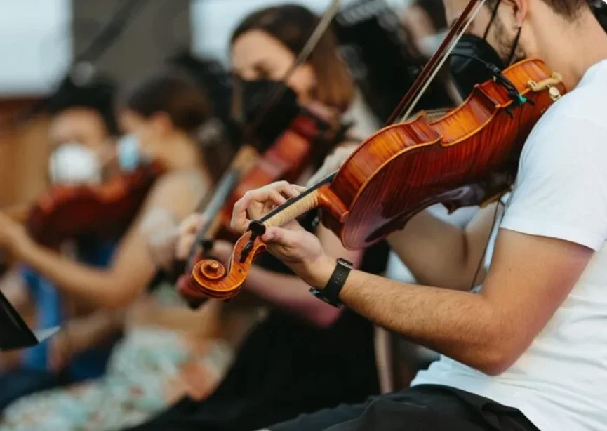 Músicos de una orquesta tocando violín